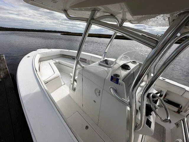 Slide: The Image of 2013 Jupiter 30 FS boat interior with helm and seating, docked by calm waters. - 15