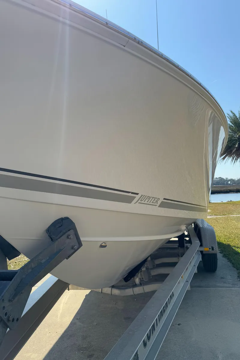 Slide: The Image of 2013 Jupiter 30 FS boat on trailer, side view, near water. - 20