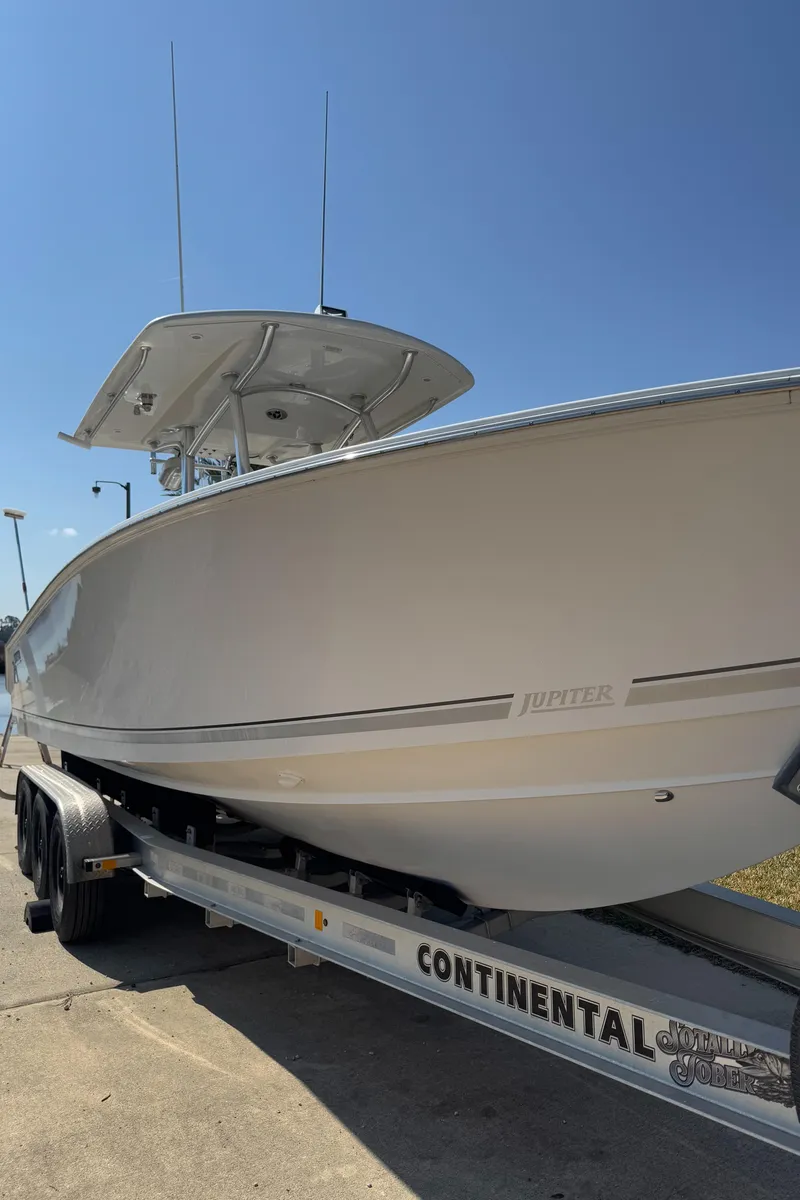Slide: The Image of 2013 Jupiter 30 FS boat on Continental trailer under clear blue sky. - 21