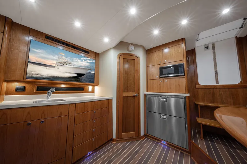 Slide: The Image of Interior of 2025 Albemarle 36 Express yacht with modern kitchen and wood finishes. - 3