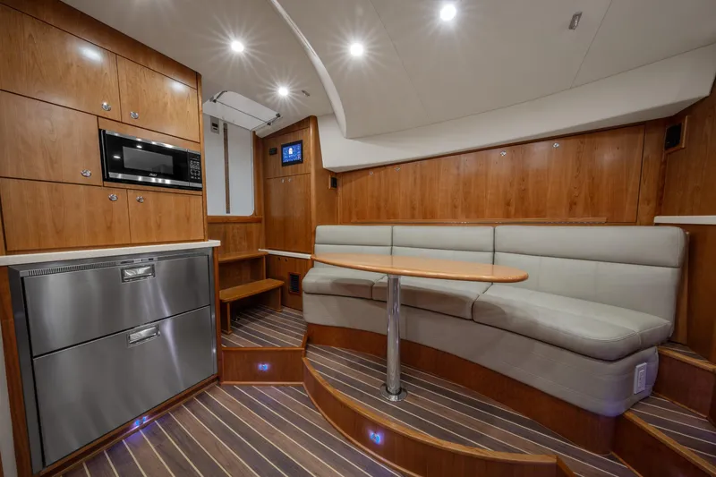 Slide: The Image of 2025 Albemarle 36 Express yacht interior with modern kitchen and cozy seating area. - 4
