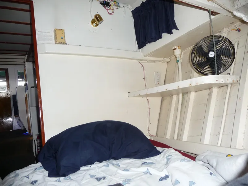 Slide: The Image of Interior of a 1956 Monk 33 Sedan Cruiser with bed, fan, and shelf. - 11