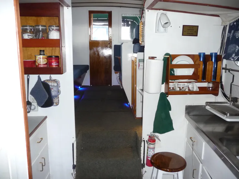 Slide: The Image of Interior of a 1956 Monk 33 Sedan Cruiser, featuring a compact kitchen and cozy living space. - 12