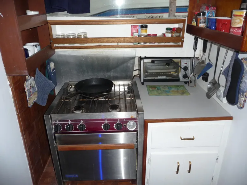 Slide: The Image of Compact kitchen in a 1956 Monk 33 Sedan Cruiser with stove, shelves, and utensils. - 13