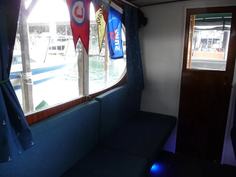 Slide: The Image of Interior of a 1956 Monk 33 Sedan Cruiser with blue seating and nautical decor. - 17