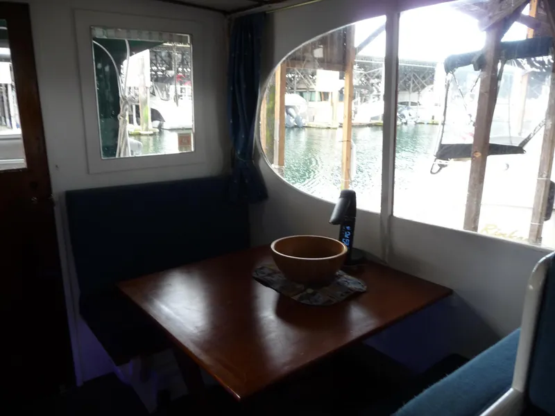 Slide: The Image of Interior of 1956 Monk 33 Sedan Cruiser with wooden table and waterfront view. - 18