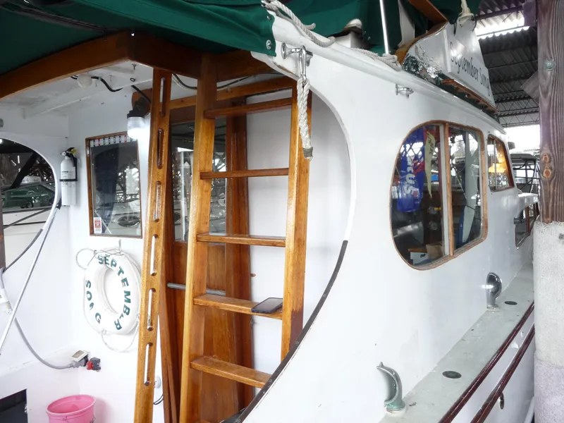 Slide: The Image of 1956 Monk 33 Sedan Cruiser with wooden ladder and green canopy in a marina setting. - 6