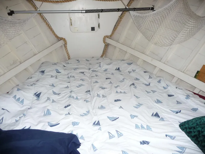 Slide: The Image of Cozy cabin interior of 1956 Monk 33 Sedan Cruiser with nautical-themed bedding. - 7