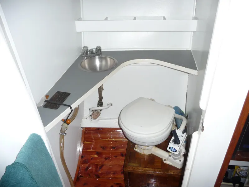 Slide: The Image of 1956 Monk 33 Sedan Cruiser bathroom with sink, toilet, and wooden floor. - 8