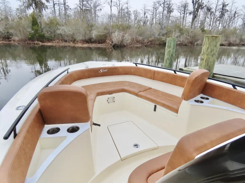 Slide: The Image of 2023 Scout 277 LXF boat interior with tan seating and cup holders. - 10