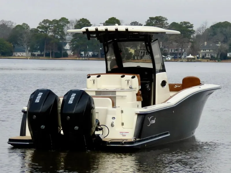 Slide: The Image of 2023 Scout 277 LXF boat with dual outboard engines on a calm lake. - 4