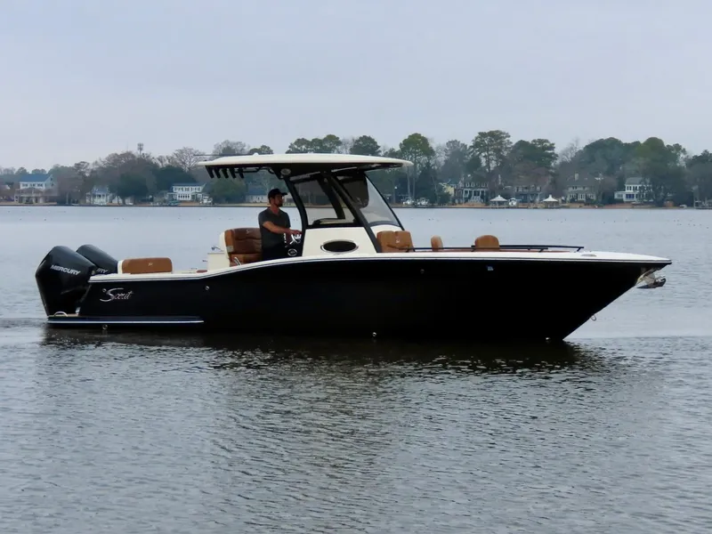 Slide: The Image of 2023 Scout 277 LXF boat on calm water with trees in the background. - 7