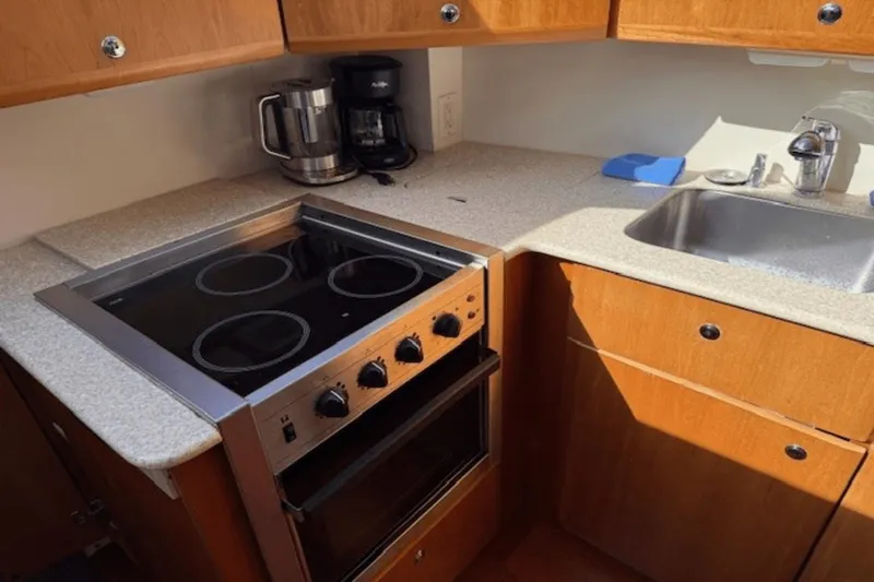 Slide: The Image of 2001 Silverton 392 Motoryacht kitchen with stove, sink, and wooden cabinets. - 19