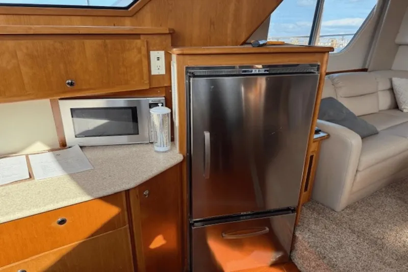 Slide: The Image of Interior of 2001 Silverton 392 Motoryacht with kitchen area, featuring fridge and microwave. - 21