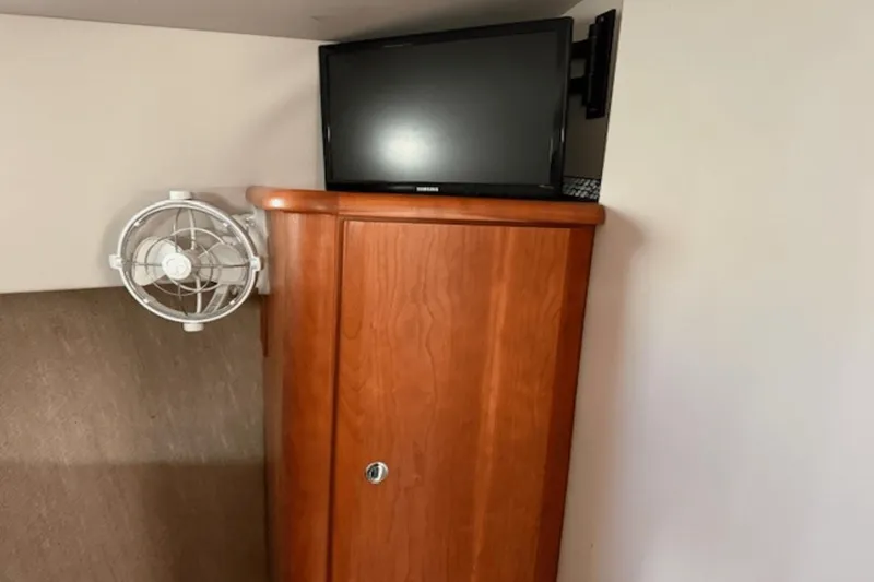 Slide: The Image of Wooden cabinet with TV and fan inside 2001 Silverton 392 Motoryacht interior. - 29