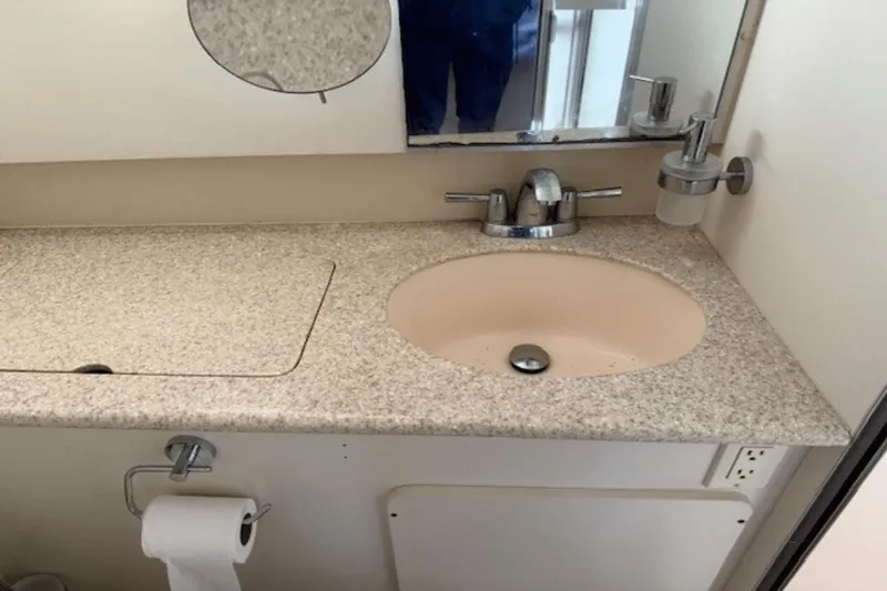 Slide: The Image of Bathroom sink area in a 2001 Silverton 392 Motoryacht, featuring a beige countertop. - 31