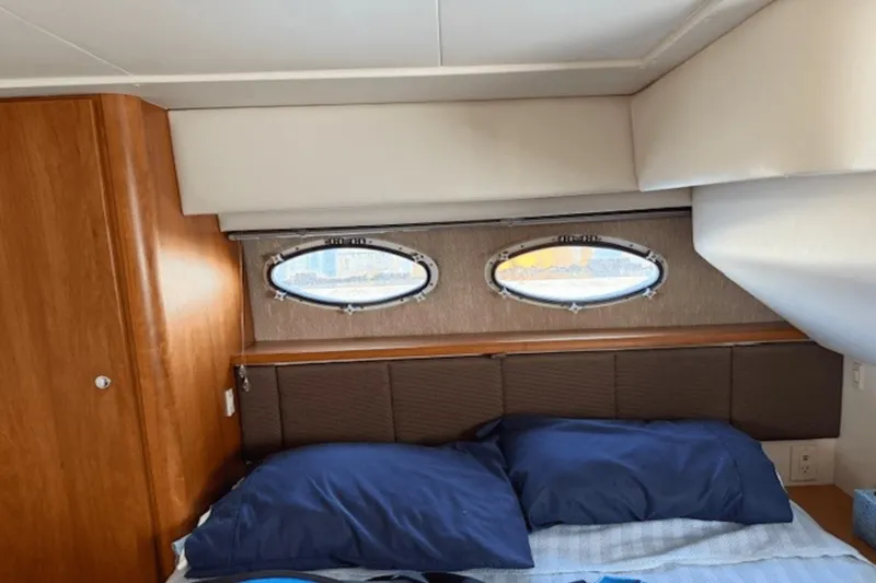 Slide: The Image of 2001 Silverton 392 Motoryacht cabin interior with bed and porthole windows. - 33