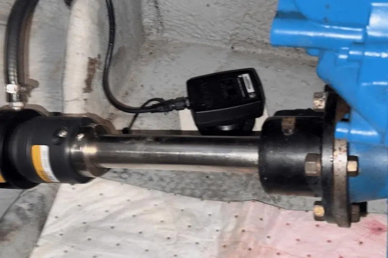 Slide: The Image of Engine component of a 2001 Silverton 392 Motoryacht, featuring a metal shaft and blue machinery. - 64