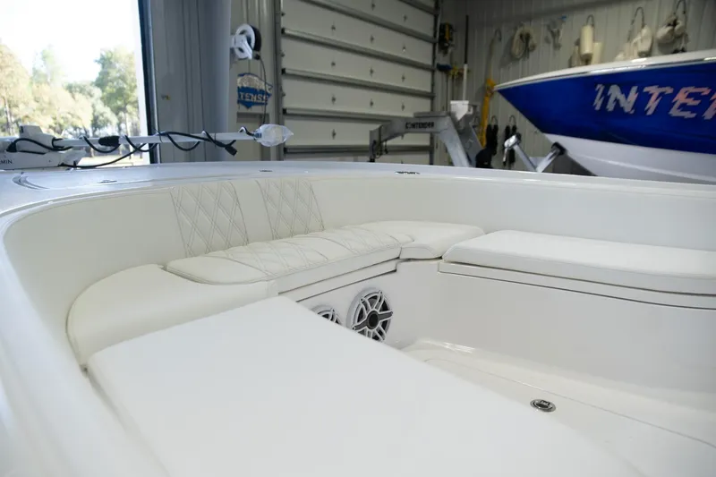 Slide: The Image of 2025 Contender 26 Bay boat interior with cushioned seating in a garage setting. - 11