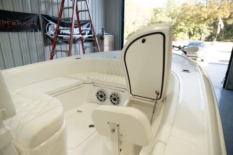 Slide: The Image of 2025 Contender 26 Bay boat interior with open storage compartment and speakers. - 17