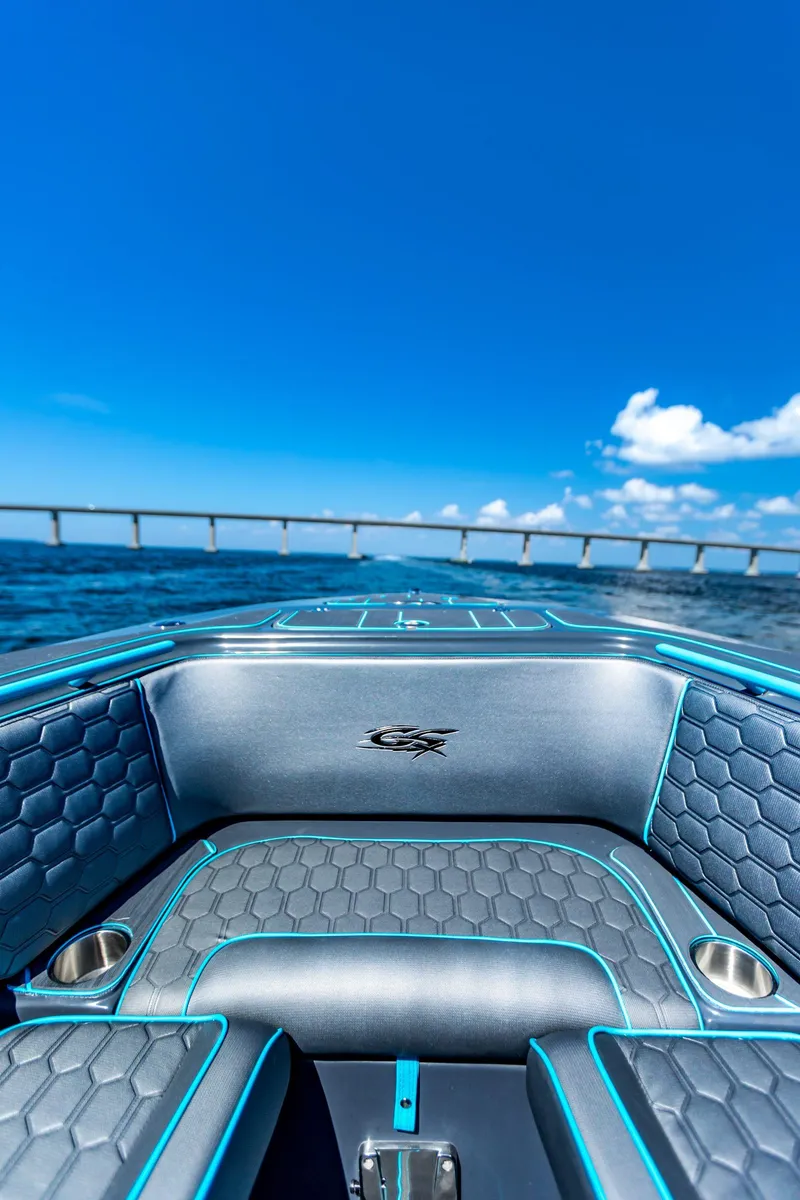 Slide: The Image of 2025 Glasstream 32 LS GSX boat interior with blue accents, under a clear blue sky. - 9