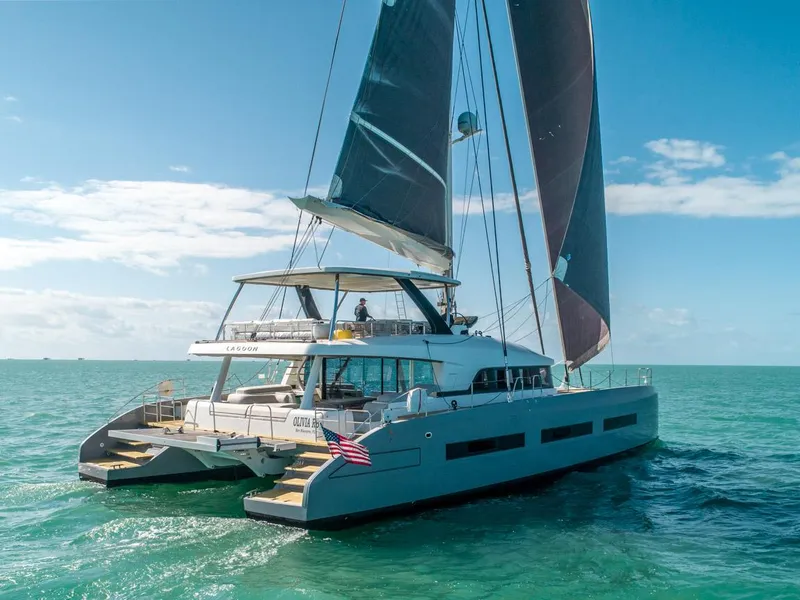 Slide: The Image of 2020 Lagoon SEVENTY 7 yacht sailing on clear blue ocean under sunny skies. - 1