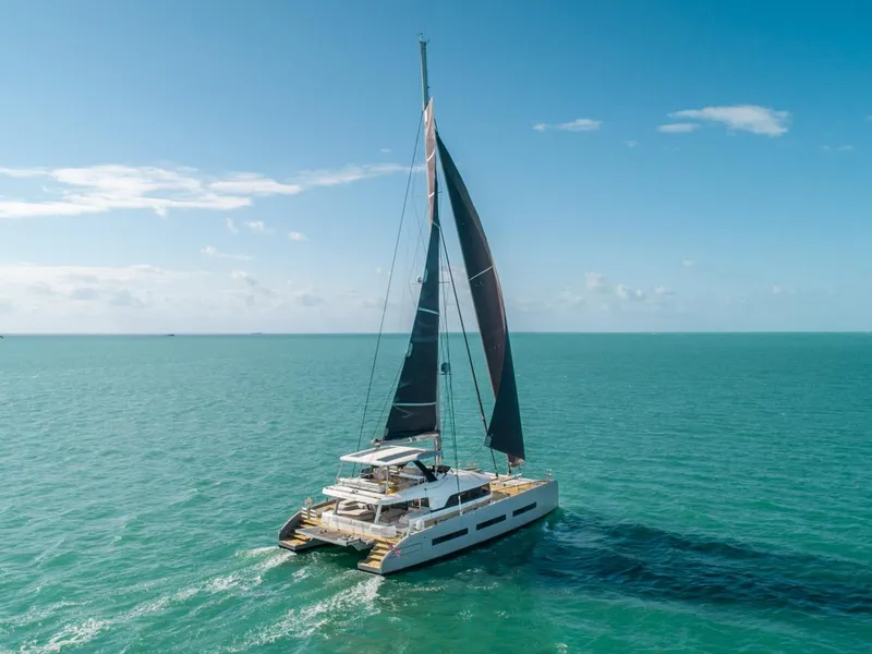Slide: The Image of 2020 Lagoon SEVENTY 7 catamaran sailing on open sea under clear blue sky. - 10