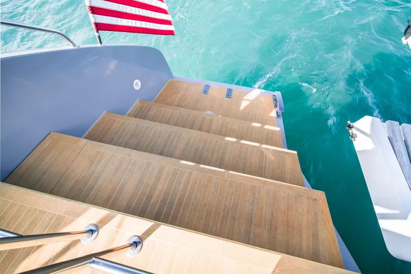 Slide: The Image of Wooden steps on a 2020 Lagoon SEVENTY 7 yacht, with ocean view and flag. - 12