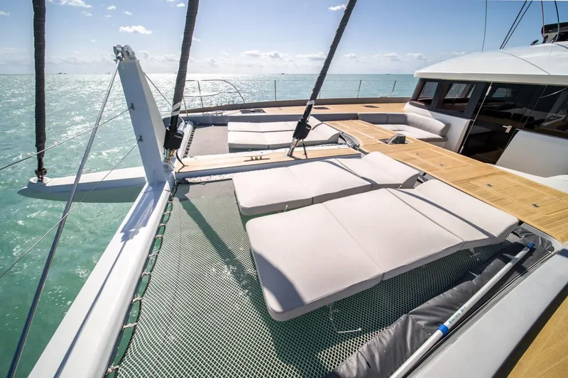 Slide: The Image of Luxurious 2020 Lagoon SEVENTY 7 catamaran with sun loungers on deck, sailing in clear waters. - 33