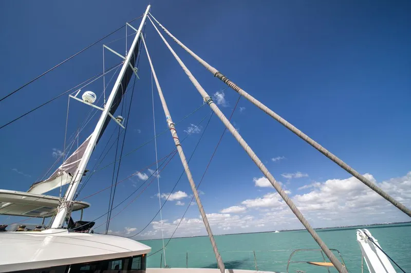 Slide: The Image of Mast and rigging of 2020 Lagoon SEVENTY 7 yacht against clear blue sky. - 38