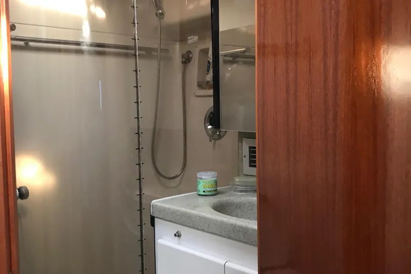 Slide: The Image of 1991 Tiara Yachts Fly Bridge bathroom with shower, sink, and wooden cabinetry. - 12