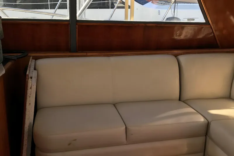 Slide: The Image of Interior of 1991 Tiara Yachts Fly Bridge with white leather seating and wooden paneling. - 25