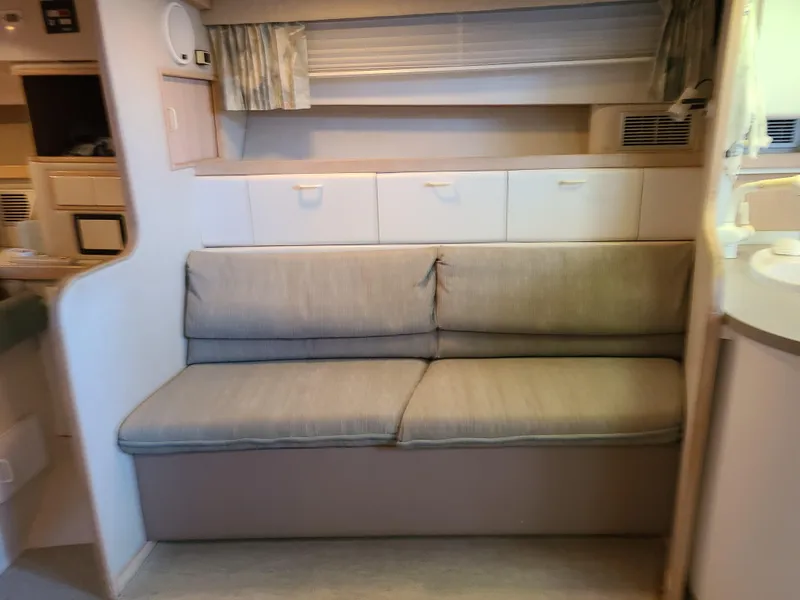 Slide: The Image of Interior of a 1992 Four Winns Express Cruiser with a comfortable sofa and storage cabinets. - 11