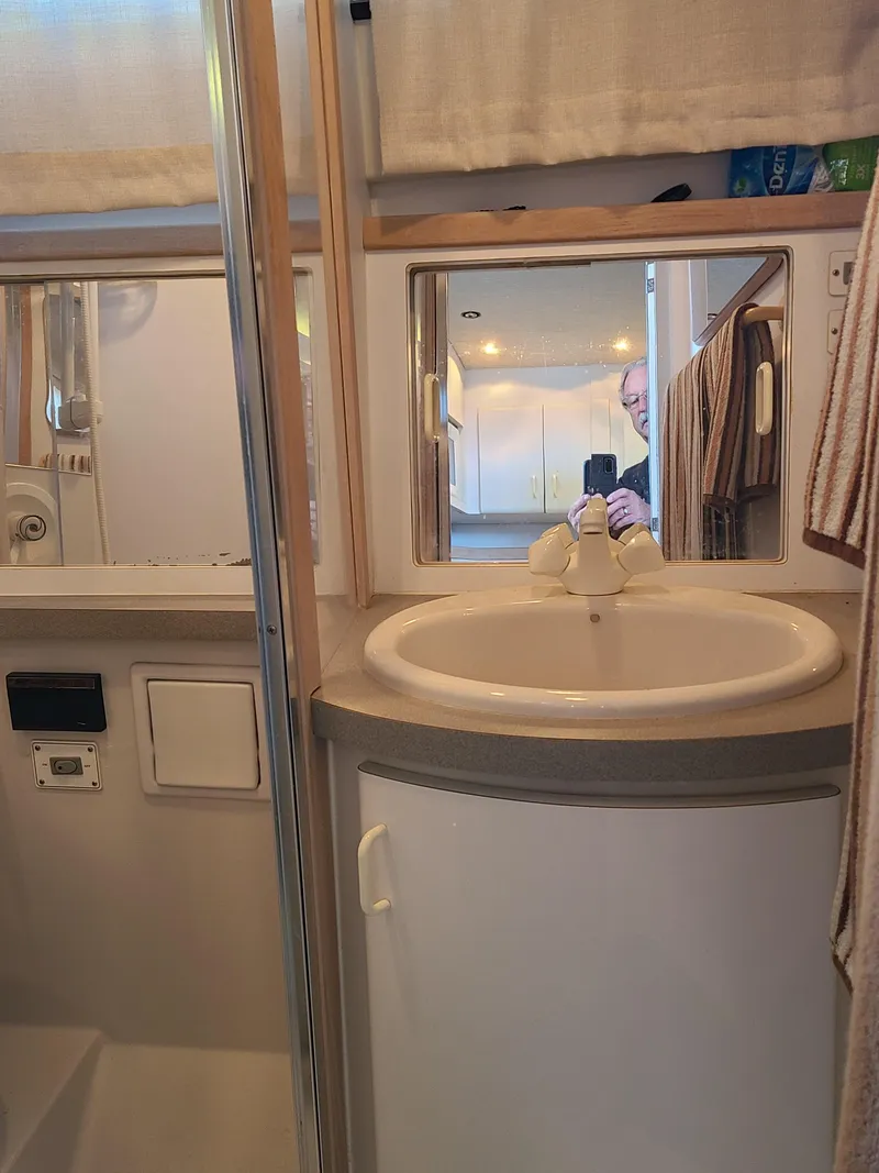 Slide: The Image of Bathroom interior of 1992 Four Winns Express Cruiser with sink and mirror. - 13
