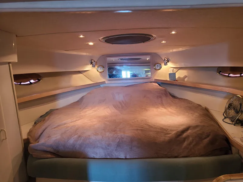 Slide: The Image of 1992 Four Winns Express Cruiser cabin interior with cozy bed and ambient lighting. - 14