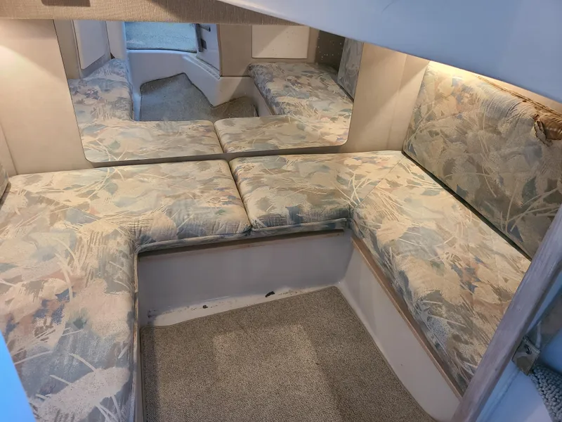 Slide: The Image of Interior of a 1992 Four Winns Express Cruiser with patterned seating and carpeted flooring. - 15