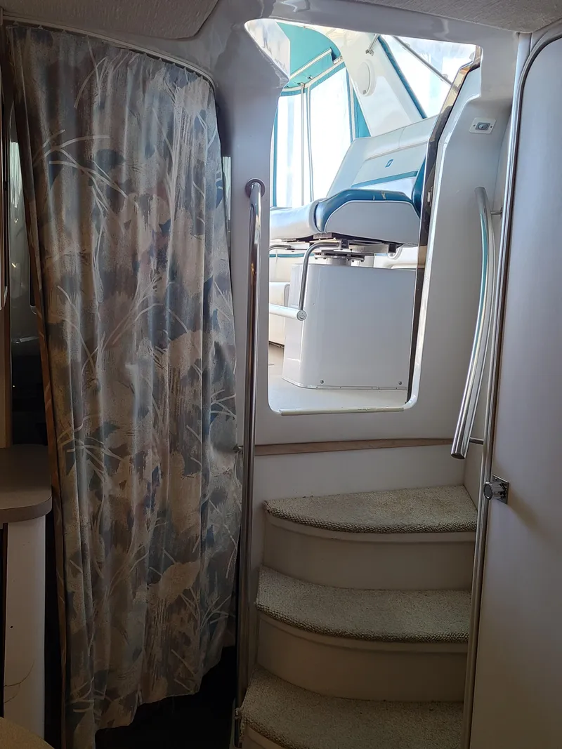 Slide: The Image of Interior view of 1992 Four Winns Express Cruiser with stairs and floral curtain. - 16