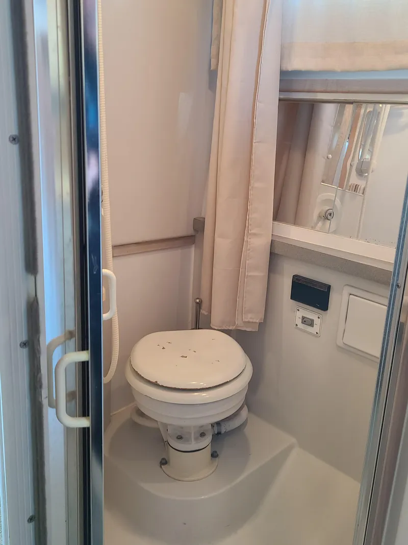 Slide: The Image of 1992 Four Winns Express Cruiser bathroom with compact toilet and shower. - 17