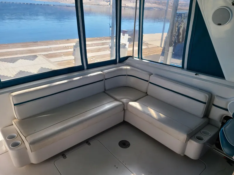 Slide: The Image of 1992 Four Winns Express Cruiser interior with white leather seating and waterfront view. - 4