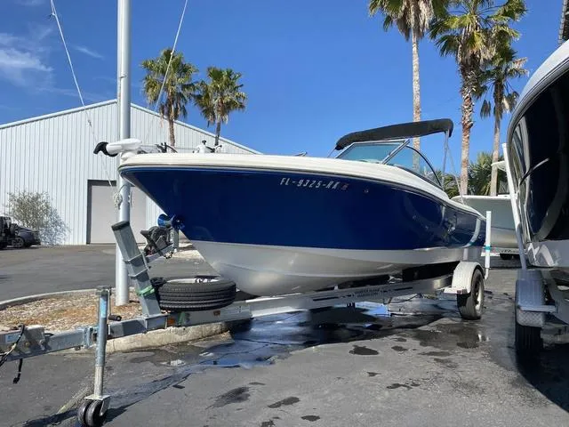 Slide: The Image of 2012 Pioneer 197 Venture boat on trailer, parked outdoors near palm trees. - 2