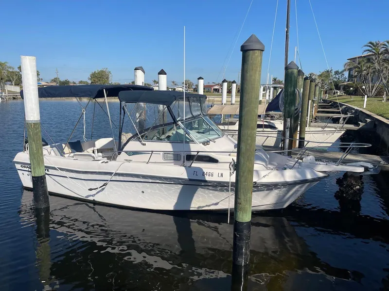 The Image of 2001 Grady-White Gulfstream 232 boat docked in a marina under clear blue skies. - 0