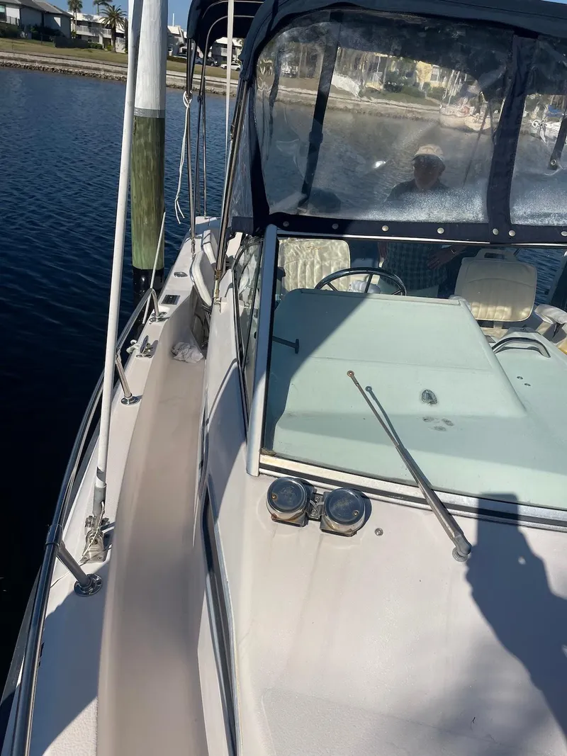 Slide: The Image of 2001 Grady-White Gulfstream 232 boat docked by the water, featuring a spacious deck. - 10