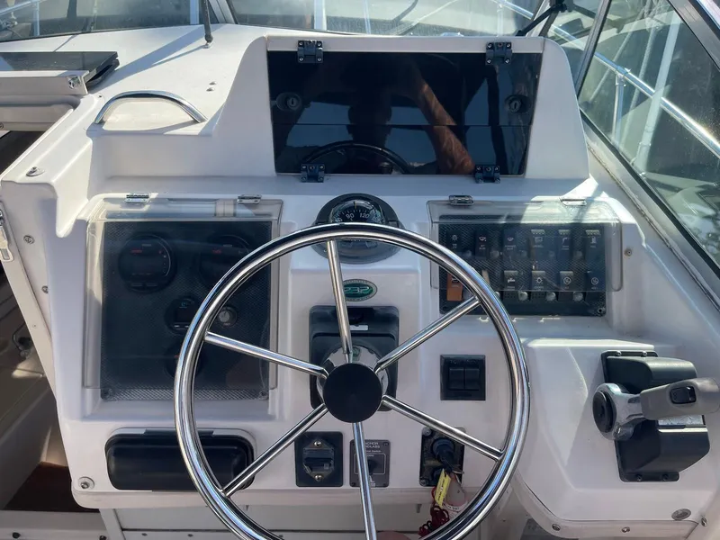 Slide: The Image of 2001 Grady-White Gulfstream 232 boat dashboard with steering wheel and control panel. - 12