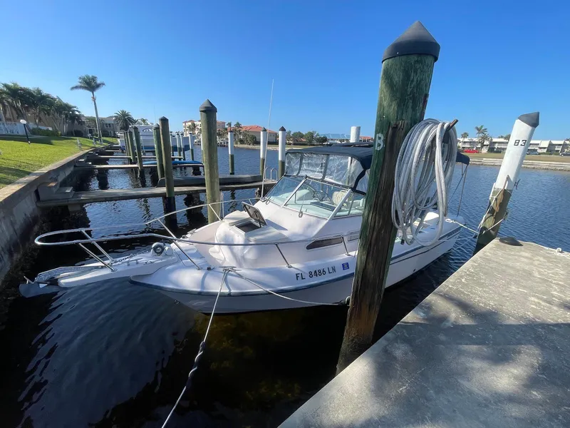 Slide: The Image of 2001 Grady-White Gulfstream 232 boat docked in a marina under clear blue skies. - 4