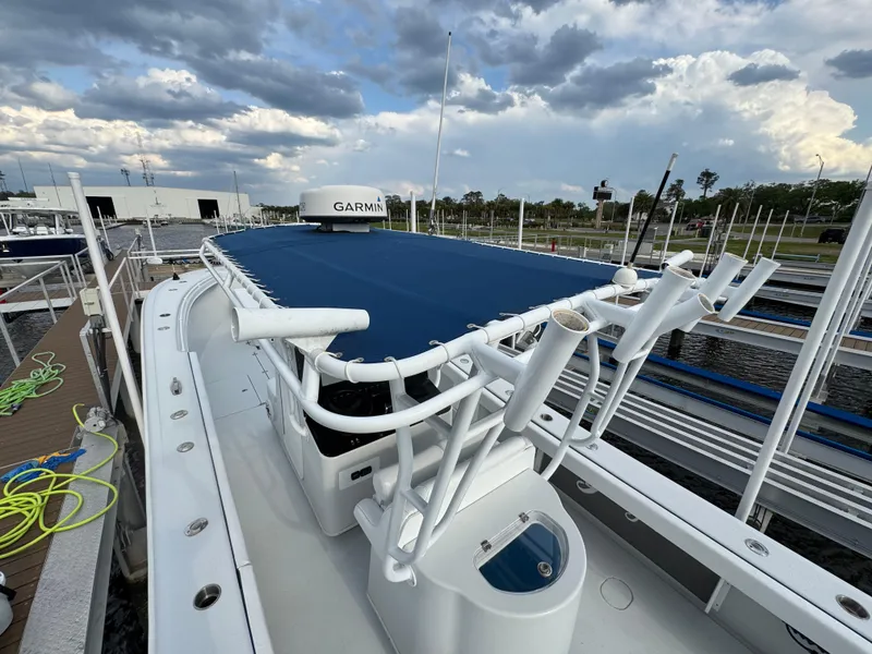 Slide: The Image of 2003 Yellowfin 36 Offshore boat docked, featuring a blue cover and Garmin equipment. - 23