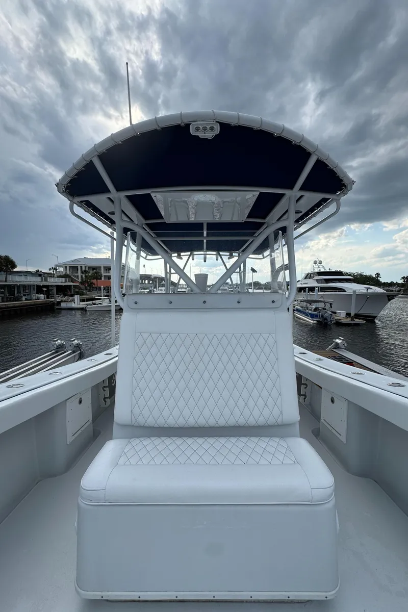 Slide: The Image of 2003 Yellowfin 36 Offshore boat with white seating, docked under cloudy skies. - 27