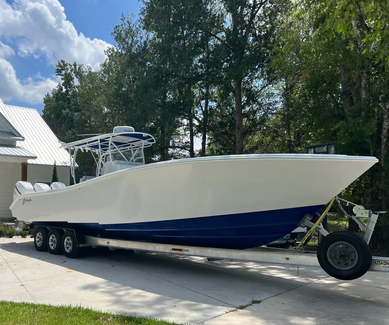 Slide: The Image of 2003 Yellowfin 36 Offshore boat on trailer, parked outdoors near trees. - 30