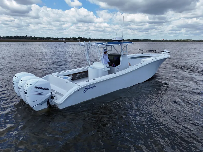 Slide: The Image of 2003 Yellowfin 36 Offshore boat with twin Mercury engines on calm water. - 4