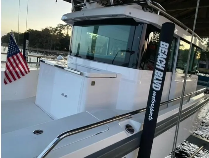 Slide: The Image of 2020 Axopar 28 boat docked, featuring sleek design and American flag. - 4
