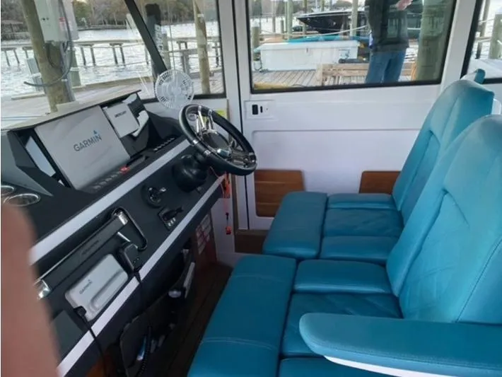 Slide: The Image of Interior of 2020 Axopar 28 boat with blue seats and navigation equipment. - 5